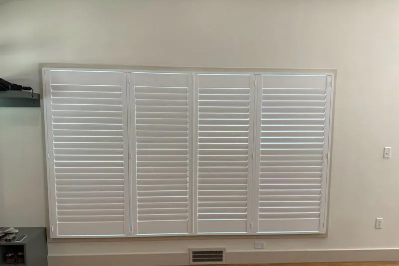 Four shutter panels closed across a wide window