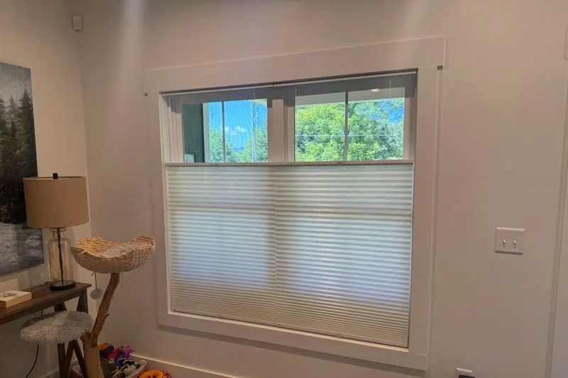 Honeycomb shade lowered from the top so daylight comes in above it