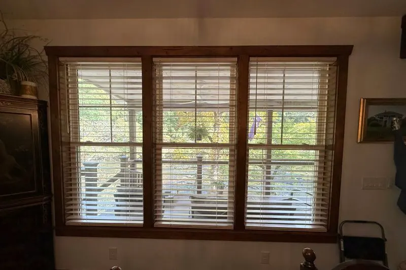 Wood blinds on three windows with stained wood trim